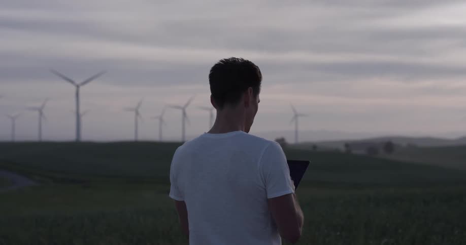 A man is on his phone outside in a rural area