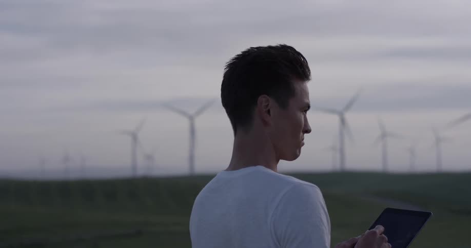 A man using a tablet in a grassy field