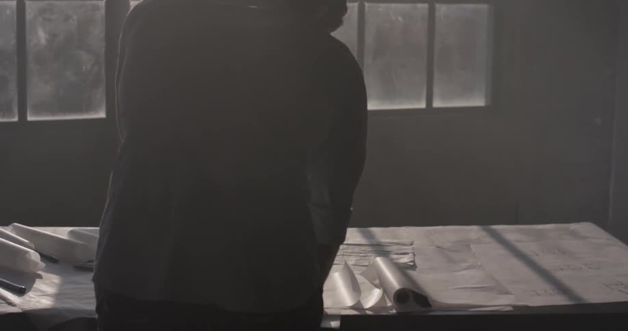 A man working on a project in front of a window