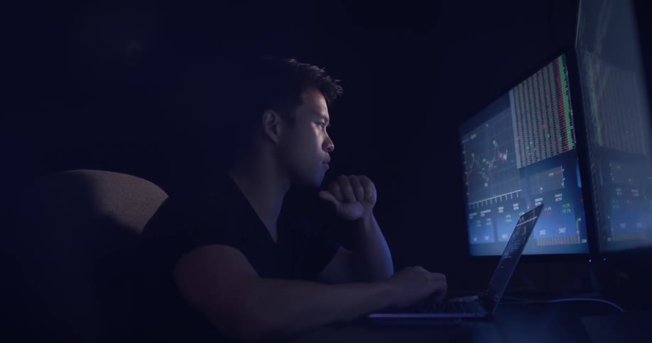 A man that is looking at a screen typing on a table
