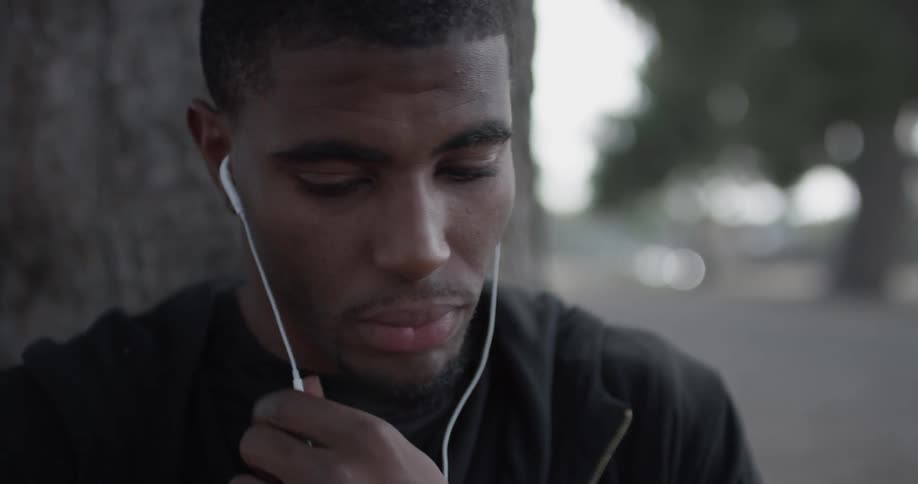 A man is putting headphones in outside