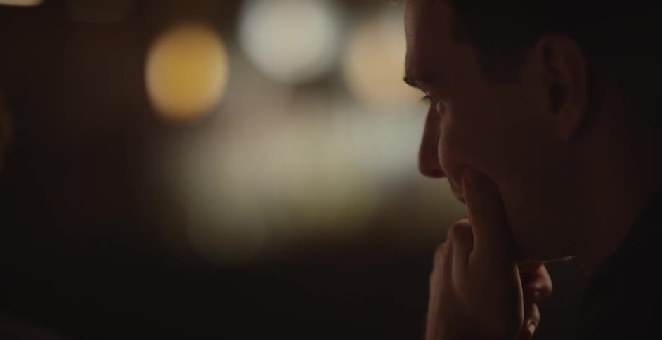 A man is contemplating something with another person in the background