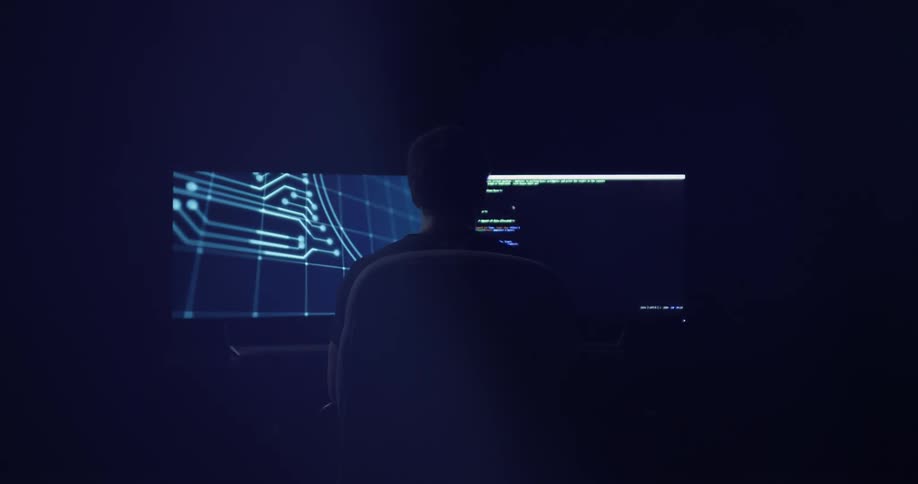 A man sitting at a desk looking at a computer screen