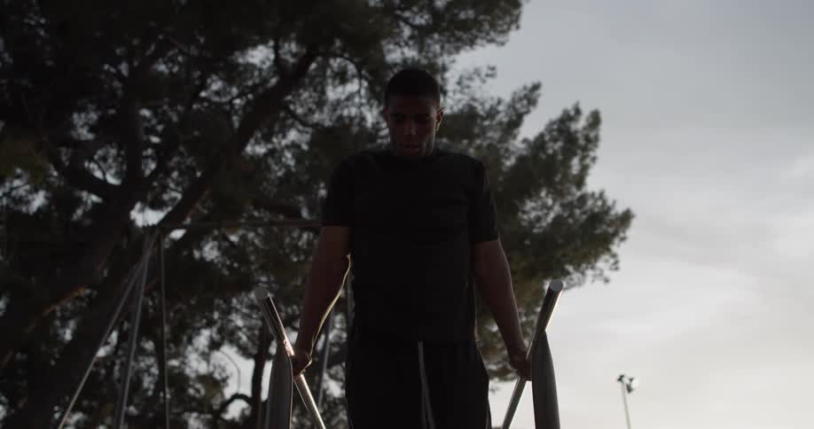 A man does push ups on parallel bars