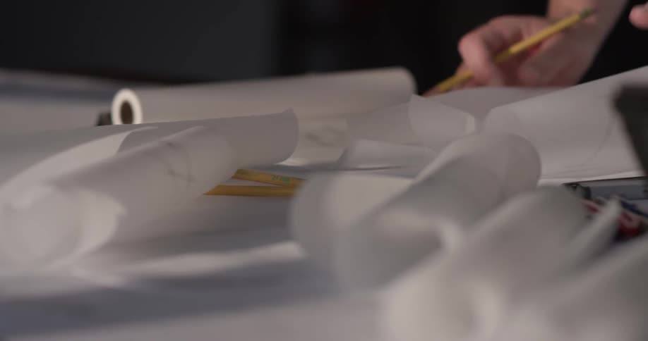 A person is writing on multiple pieces of paper