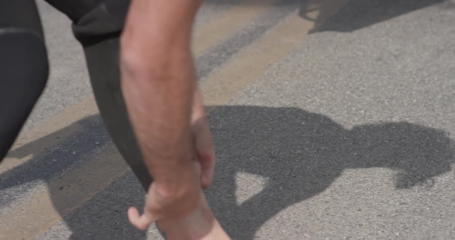 The shadow of a person getting dressed in a wetsuit