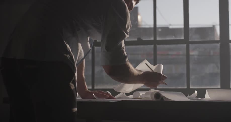 Man smooths out a piece of paper on the table