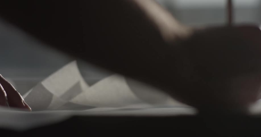 A person draws with a pencil on the paper