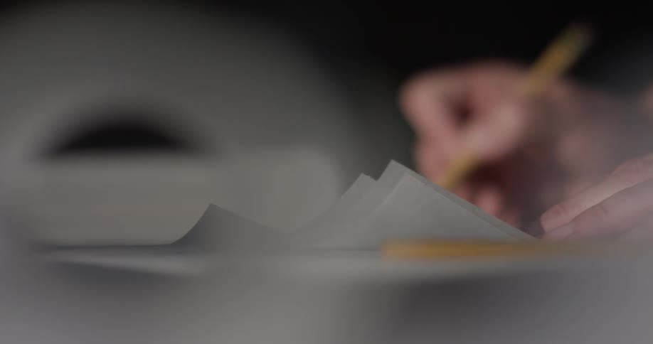 A person is writing on a piece of paper