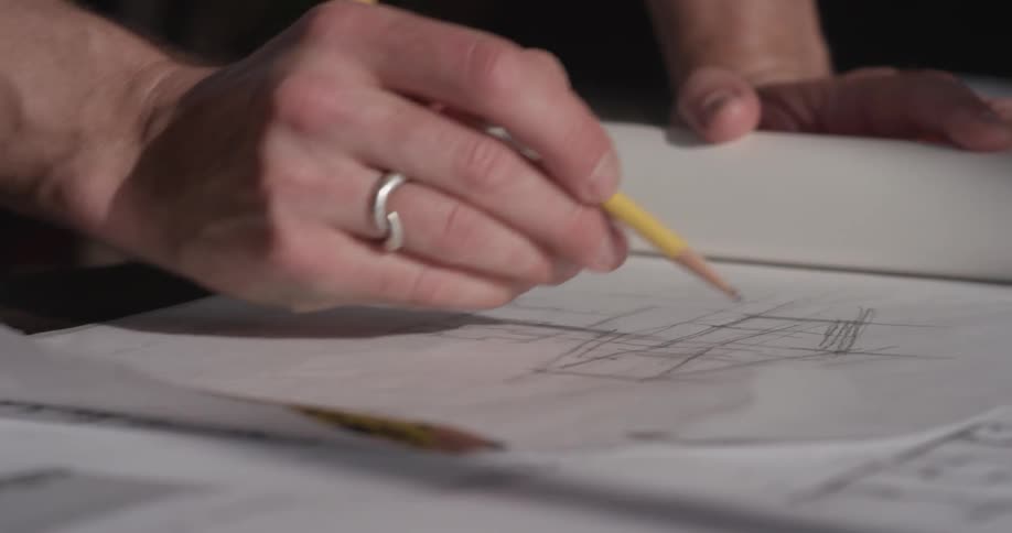 A person drawing plans on a piece of paper