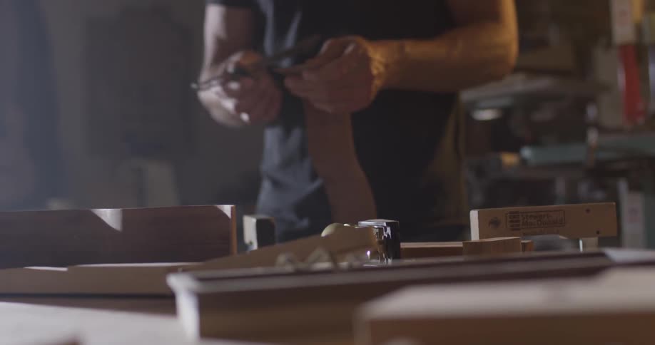 A man sets something down on the table and picks another item up