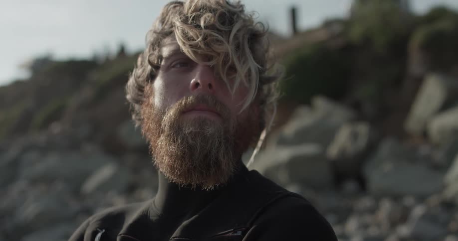 A man in a wetsuit looking around