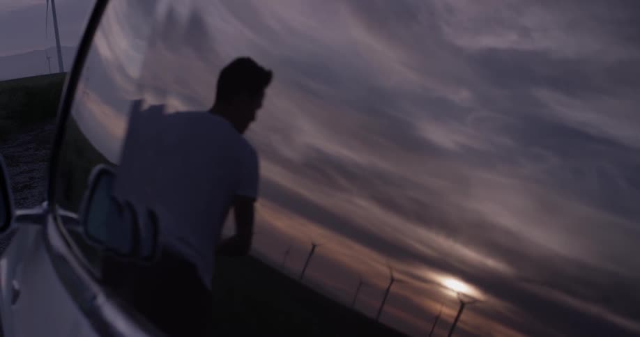 A man is outside by the sunset