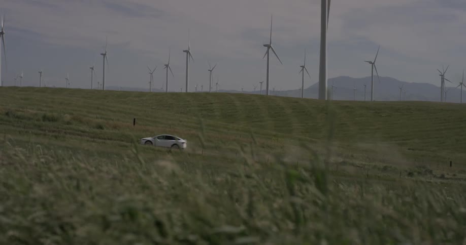 Wind turbines are rotating in field on windy day