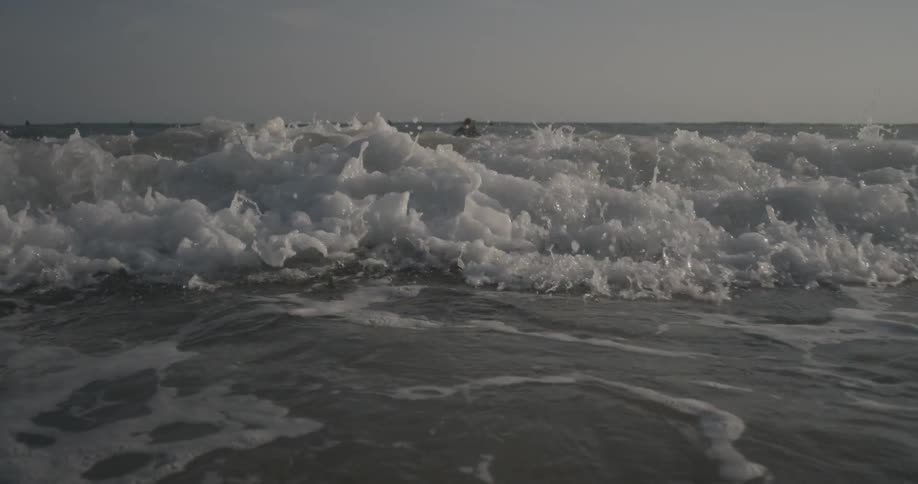Tide rushes toward the beach on a sunny day