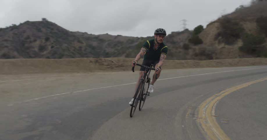 Man rides his bike on a winding country road