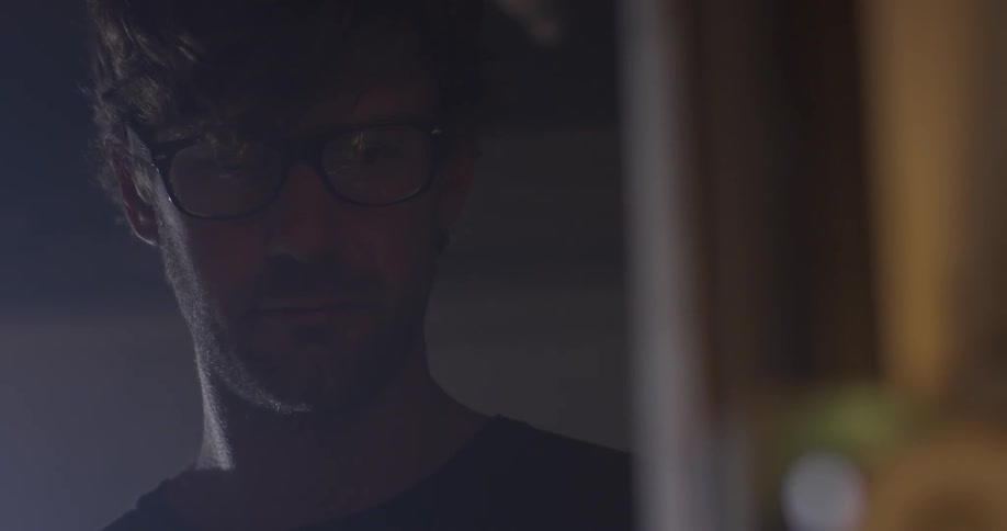 A man wearing glasses looking into the distance