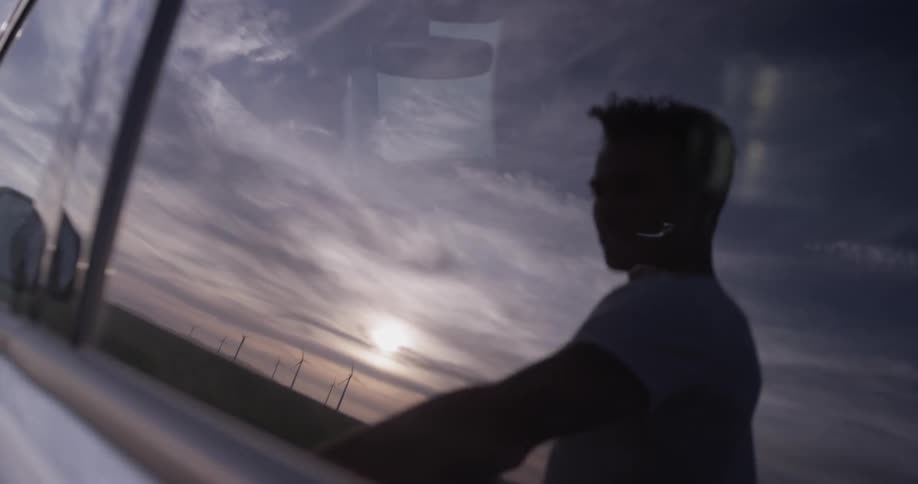 A man getting out of a car holding a tablet
