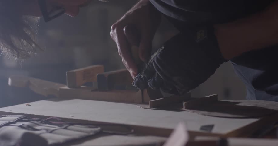 A man using a chisel on a piece of wood