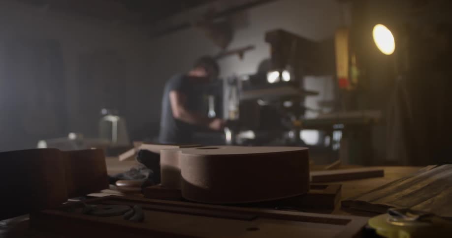 Multiple pieces of a guitar scattered across a table