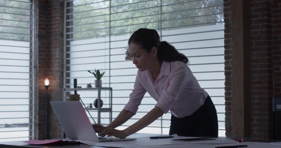 A woman that is writing on a laptop