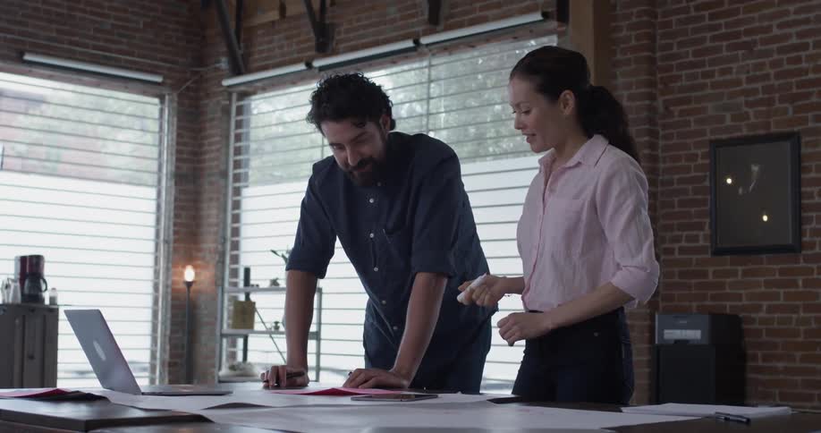 A man and woman looking at some things on a piece of paper