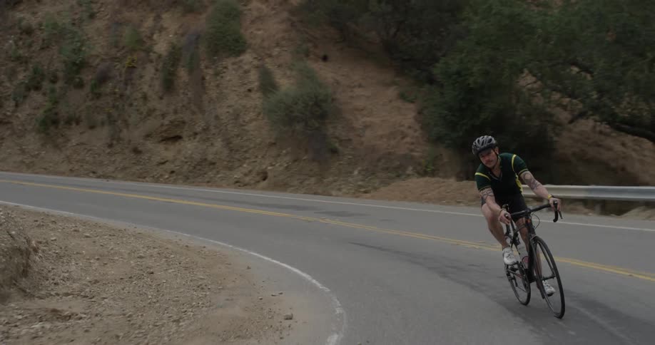A man that is riding a bicycle down a mountain