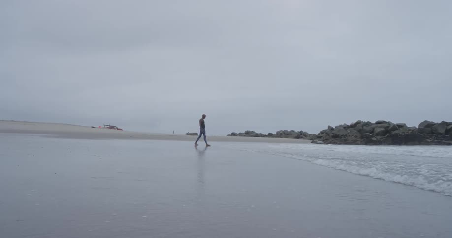 A person that is walking through the edge of the ocean