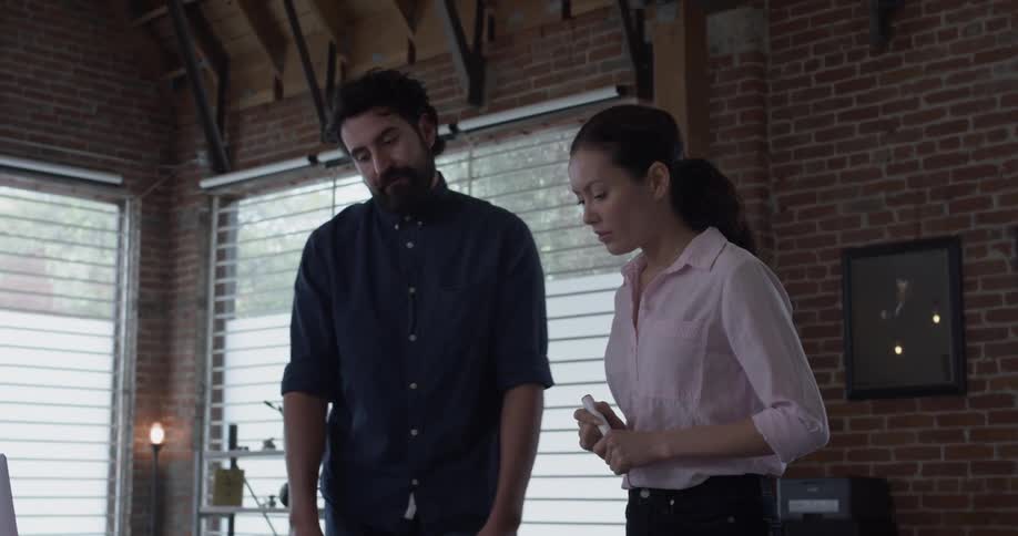A man and woman have a discussion while pointing to something