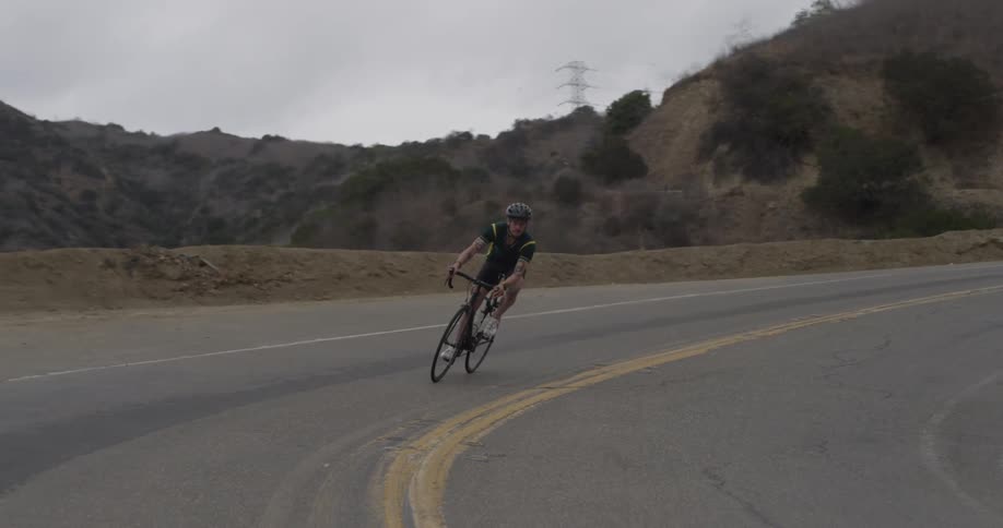 Man bicycles along mountain road