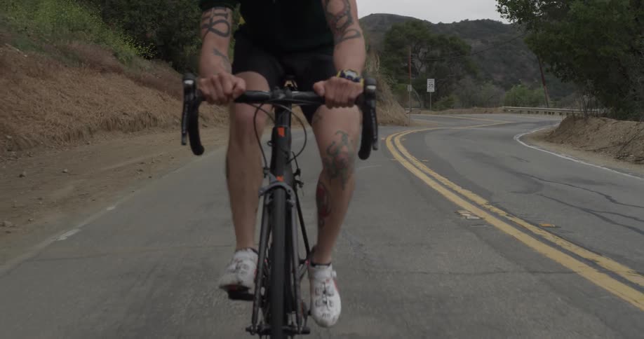 Man bicycles along mountain road