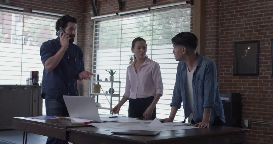 People stand at conference table talking