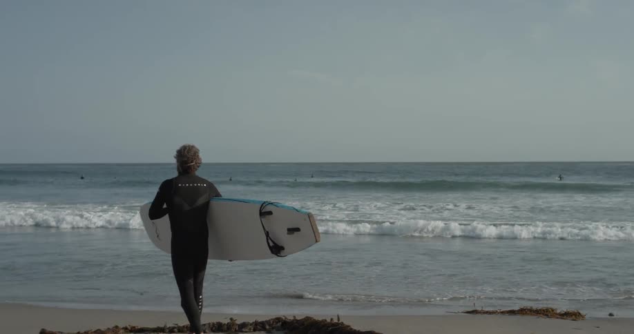 A man carrying a surfboard next to the ocean