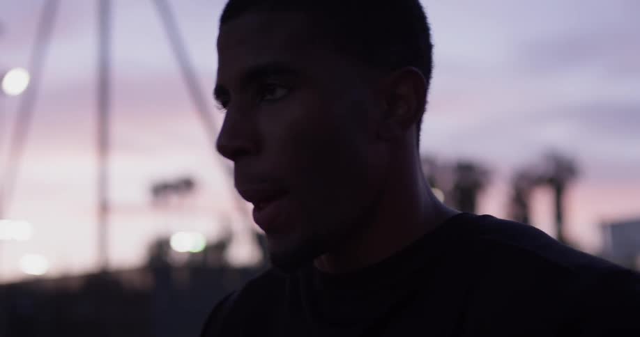 A man breathing heavily and looking up at dusk
