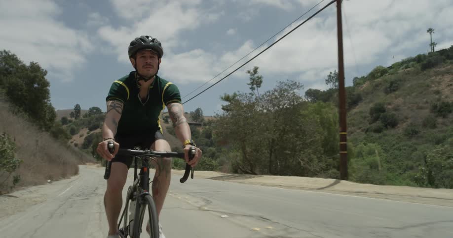 A man rides a bike down a country road