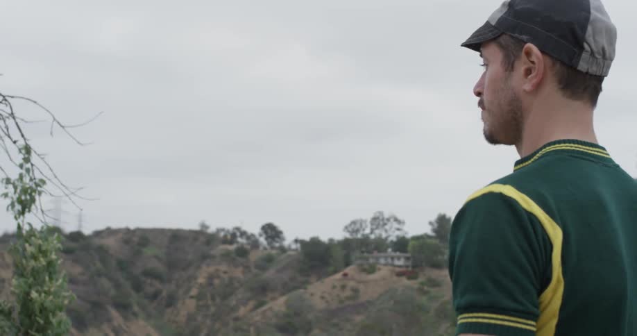 A man that is taking off a bicycle helmet