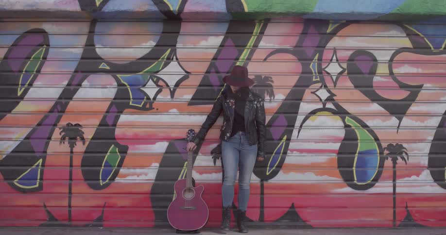 A woman standing in front of a wall with graffiti