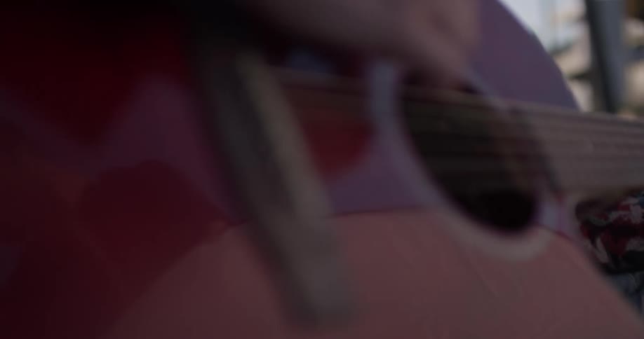 Woman strums on her guitar during the day