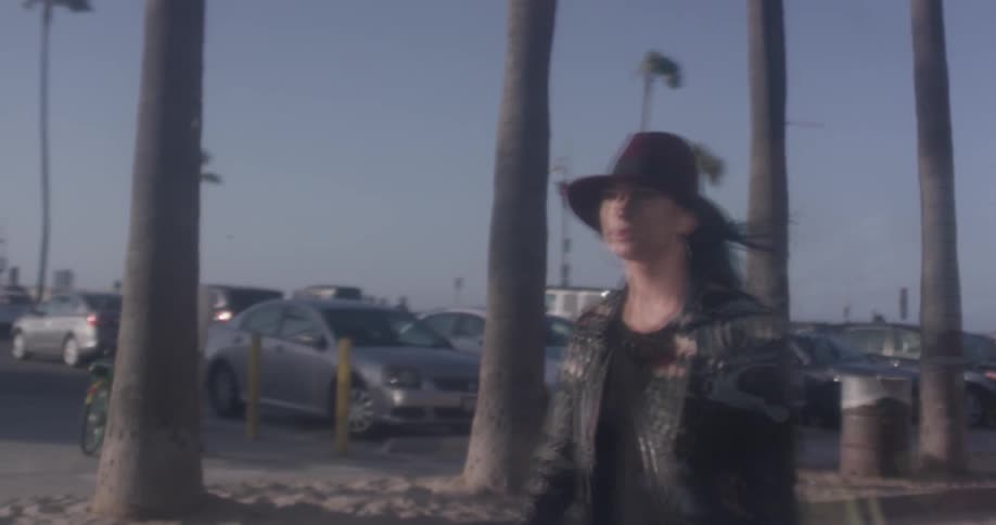 A woman can be seen in the reflection of the window walking by on the sidewalk at the beach