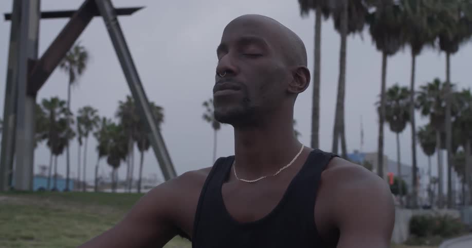 A man sitting in the grass with his eyes closed