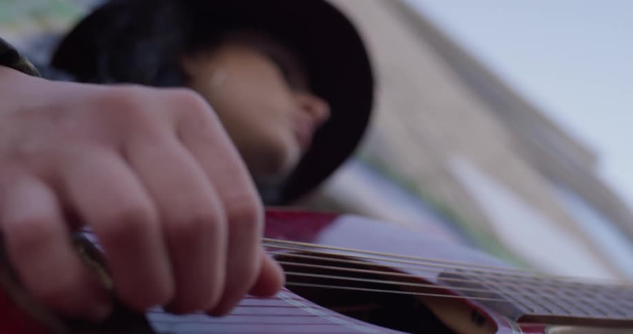 A woman is playing guitar outside