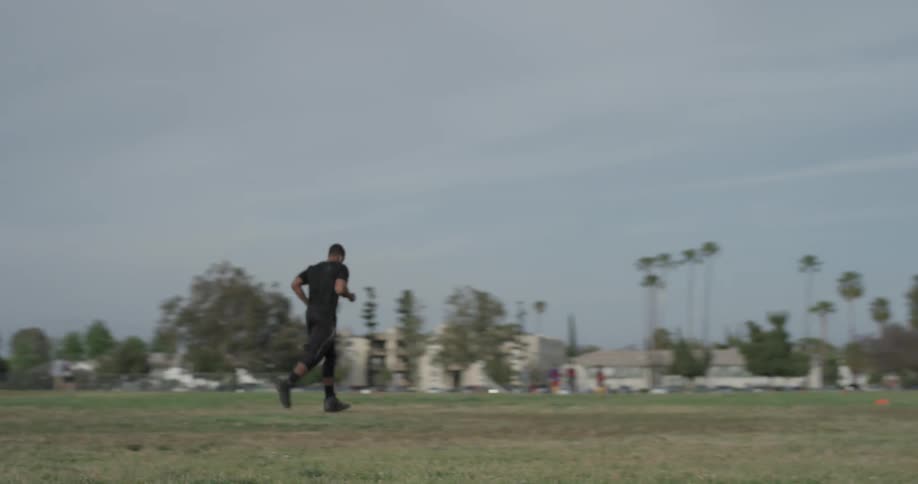 A man jogging through a grass field