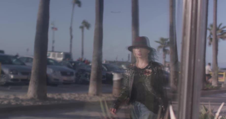 A woman walking down the street with a guitar