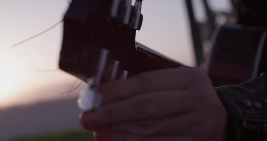 A person that is tuning a guitar by using the turning pins