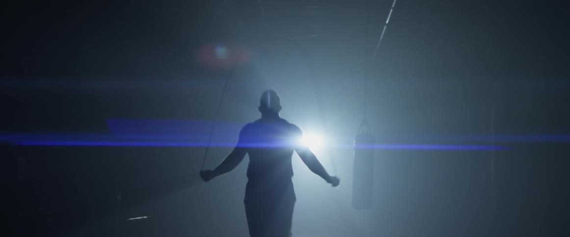 A man jumping rope in a gym in front of a punching bag