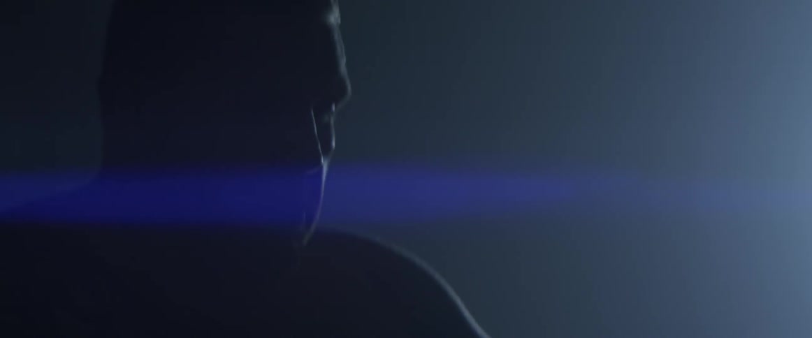 A man sits in the dark wrapping his hand