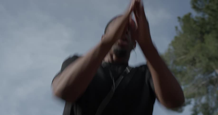 A man with earbuds jumping up and down