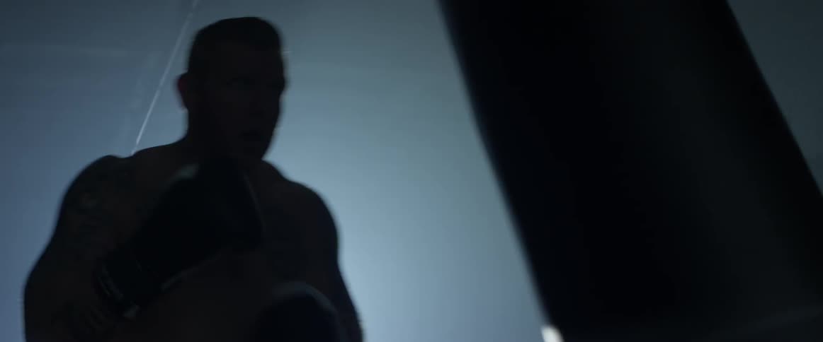 A man is hitting a boxing bag