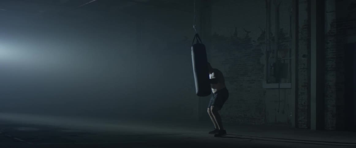 A man hitting a punching bag at a gym