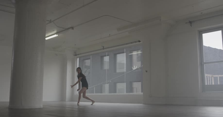 A woman that is dancing around spinning around in a room